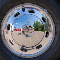 Reflective chrome wheel capturing a vibrant outdoor scene in Nelson, Wisconsin.